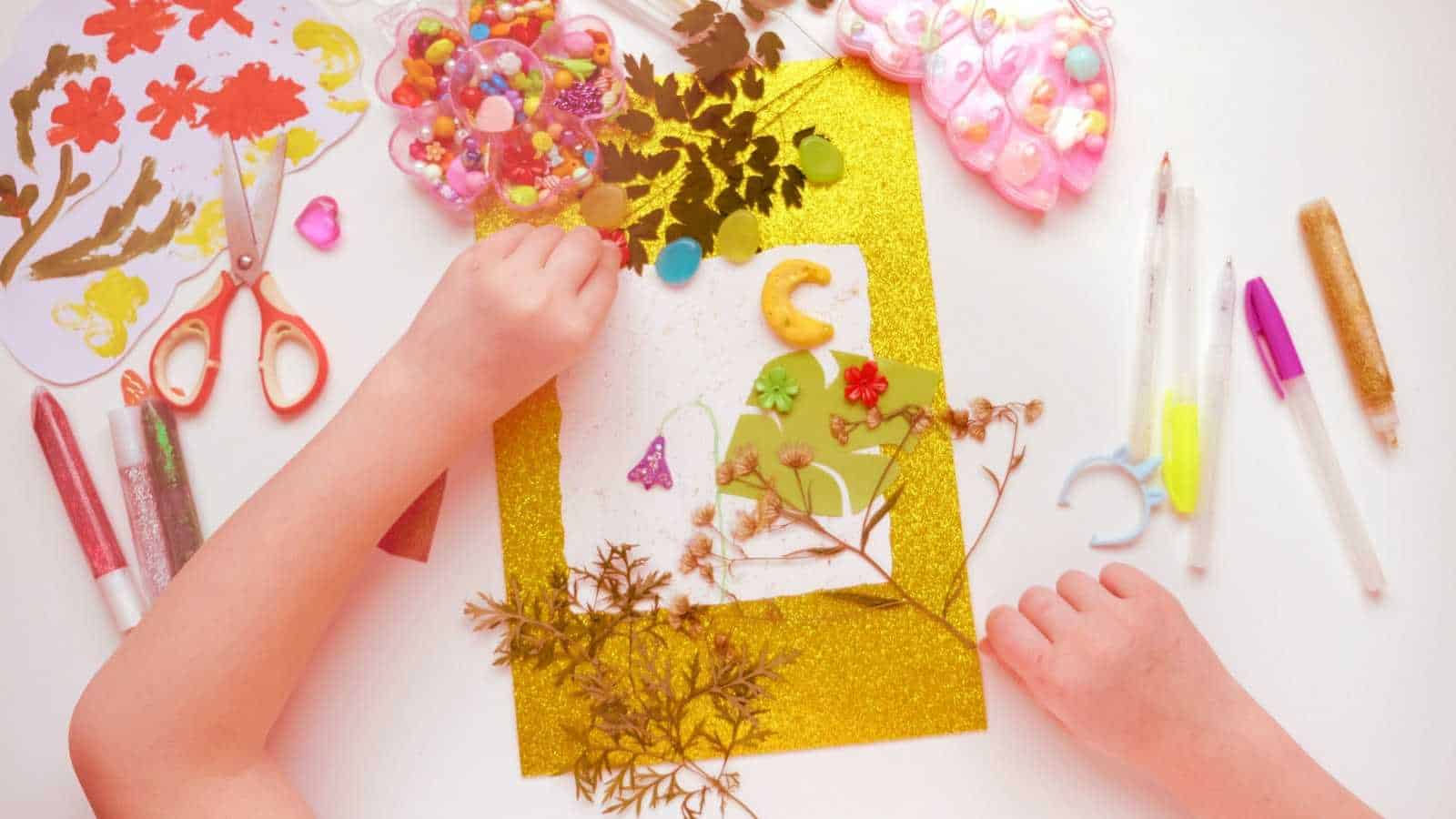 A child making crafts from natural dry plants, flowers, grass and leaves